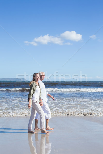 Happy couple strolling barefoot on the beach Stock photo © wavebreak_media