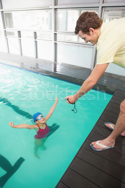 Swimming coach showing time to little girl Stock photo © wavebreak_media