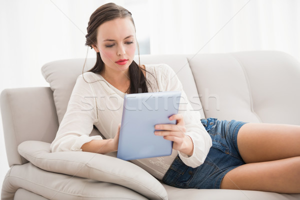 Pretty brunette using tablet on the couch Stock photo © wavebreak_media