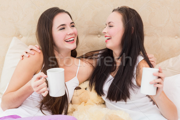 Pretty friends having coffee on bed Stock photo © wavebreak_media