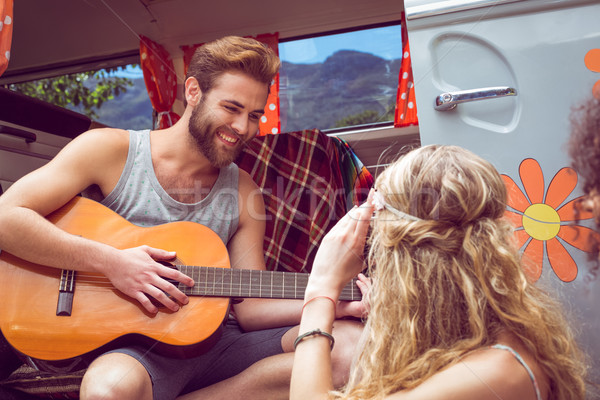 Stock photo: Hipster playing guitar for girls