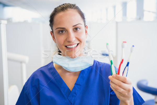 肖像 微笑 牙科醫生 顯示 牙刷 牙科 商業照片 © wavebreak_media