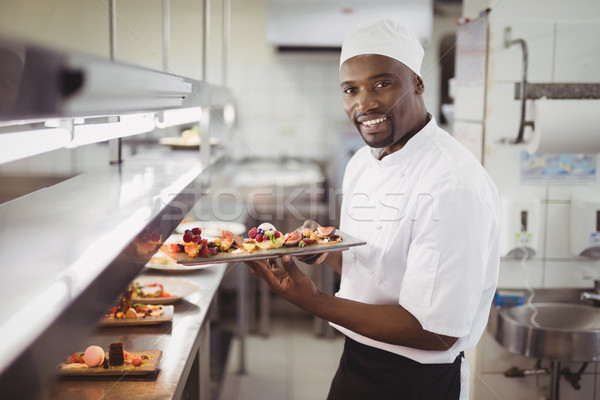 Chef holding dessert tray in commercial kitchen Stock photo © wavebreak_media