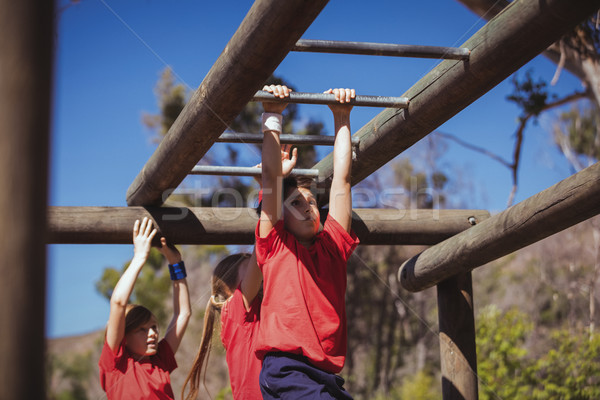 Kids climbing monkey bars during obstacle course training Stock photo © wavebreak_media