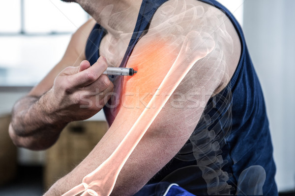 Stock photo: Highlighted arm of strong man injecting anabolic steroid at gym