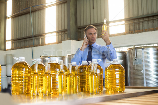 Manager talking on mobile phone while examining olive oil Stock photo © wavebreak_media