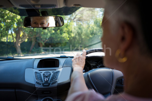 Senior femeie uita vedere din spate oglindă conducere Imagine de stoc © wavebreak_media