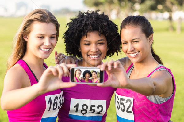 Runners supporting breast cancer marathon and taking selfies Stock photo © wavebreak_media