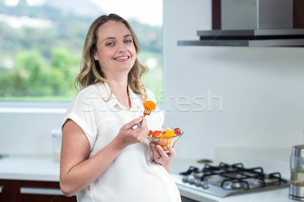 Zdjęcia stock: Kobieta · w · ciąży · jedzenie · owoce · Sałatka · kuchnia · kobieta