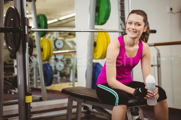 Femme souriante séance barbell banc gymnase femme [[stock_photo]] © wavebreak_media