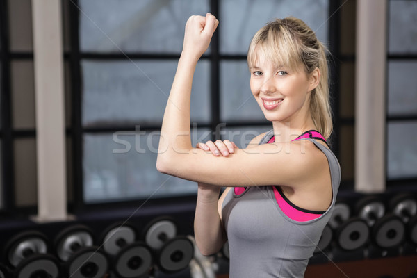 Fitt szőke nő mutat bicepsz tornaterem nő Stock fotó © wavebreak_media