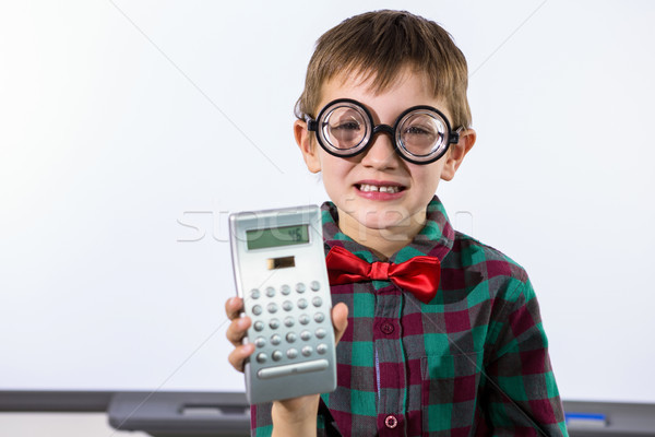 Stock photo: Smiling boy holding calculator in classroom