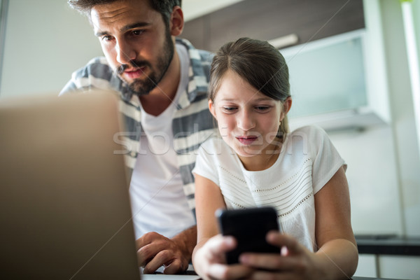 [[stock_photo]]: Père · fille · utilisant · un · ordinateur · portable · téléphone · portable · salon · maison