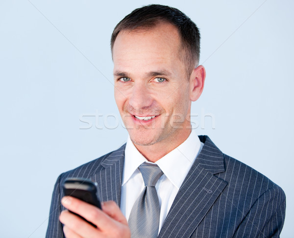 Confident businessman sending a text with his  phone  Stock photo © wavebreak_media