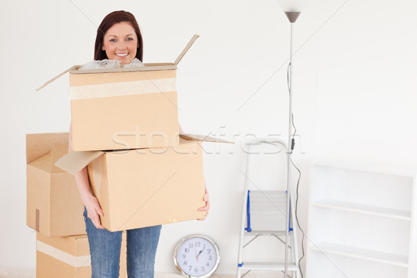 Attractive red-haired woman holding some carboard boxes at home Stock photo © wavebreak_media