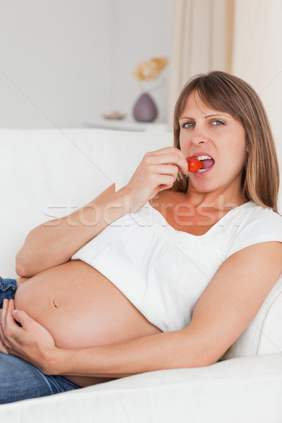 Vonzó terhes nő eszik eprek kanapé mosoly Stock fotó © wavebreak_media