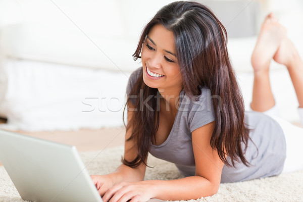 close up of a smiling woman lying on a carpet with notebook in livingroom Stock photo © wavebreak_media