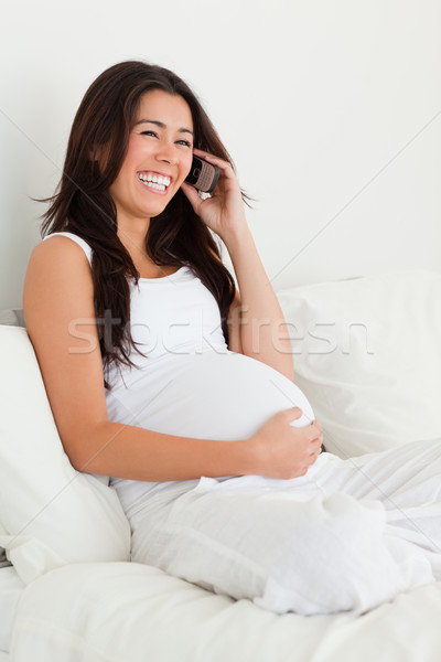 Beautiful pregnant woman on the phone while lying on a bed at home Stock photo © wavebreak_media