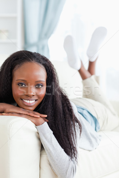 Smiling young woman lying on sofa Stock photo © wavebreak_media