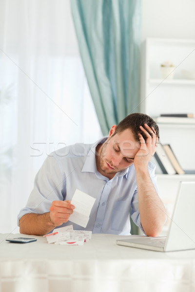 Concerned young businessman looking at an invoice Stock photo © wavebreak_media