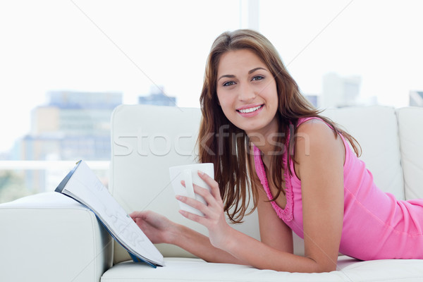 Jeune femme souriant lecture potable café livre [[stock_photo]] © wavebreak_media