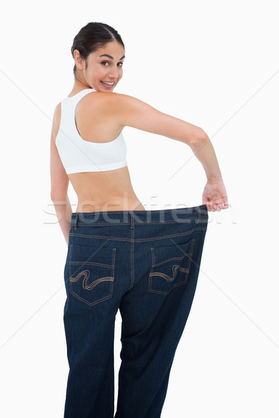Rear view of a happy woman who lost a lot of weight against white background Stock photo © wavebreak_media