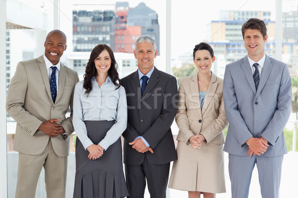 Business team smiling and standing upright side by side with their hands crossed Stock photo © wavebreak_media