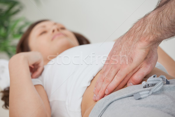 Stock photo: Doctor examining the stomach of his patient in a room