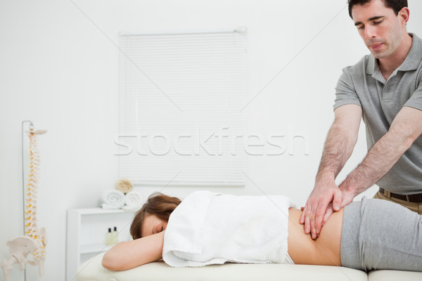 Masseur massaging the back of a brunette woman in a room Stock photo © wavebreak_media