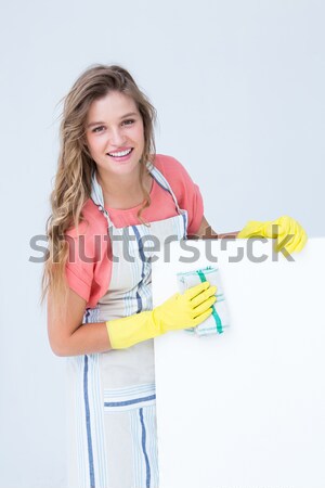 Femme souriante tablier gants en caoutchouc nettoyage blanche surface [[stock_photo]] © wavebreak_media