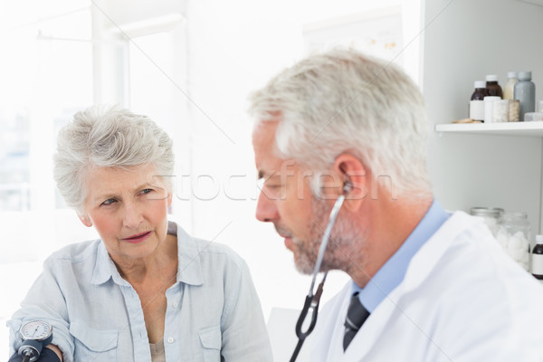 Stock photo: Doctor taking the blood pressure of his retired patient