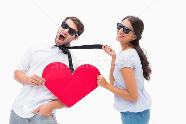 Brunette pulling her boyfriend by the tie holding heart Stock photo © wavebreak_media