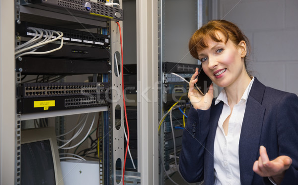 Pretty computer technician talking on phone beside open server Stock photo © wavebreak_media
