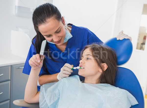 Pediatric dentist brushing teeth to her young patient  Stock photo © wavebreak_media