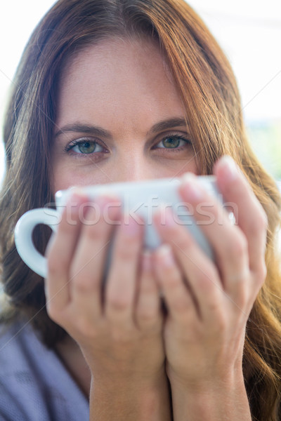 Stock photo: Pretty brunette enjoying a cappuccino 