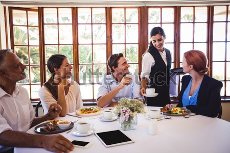 Group of friends interacting with each other while having meal together Stock photo © wavebreak_media