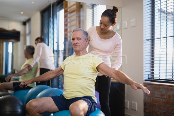 Female therapist looking at male patient exercising with arms outstretched Stock photo © wavebreak_media