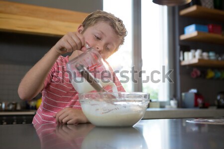 Girl spreading cream on cake seen through glass Stock photo © wavebreak_media