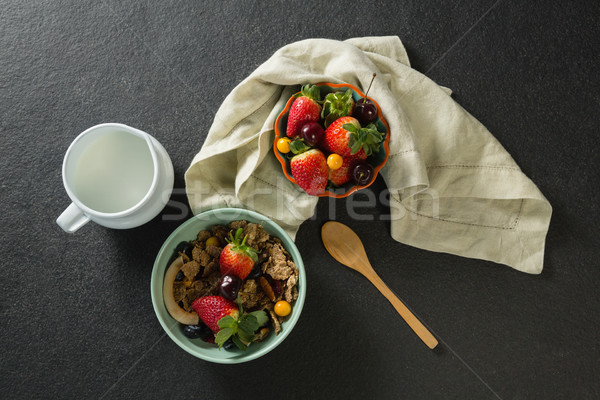 Stock photo: Bowl of breakfast cereals, fruits with spoon and milk