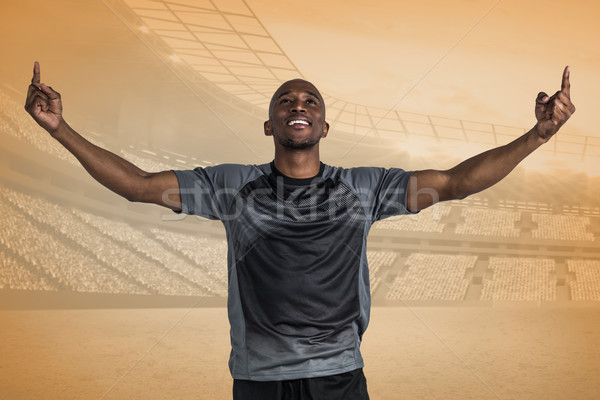 Stock photo: Composite image of happy sportsman with arms raised after victor
