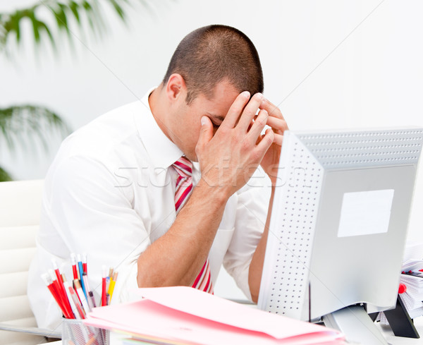 Stock photo: Frustrated businessman working at a computer in the office