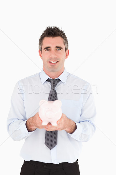 Man showing a piggy bank against a white background Stock photo © wavebreak_media