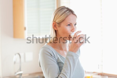 Young woman in the kitchen drinking water Stock photo © wavebreak_media