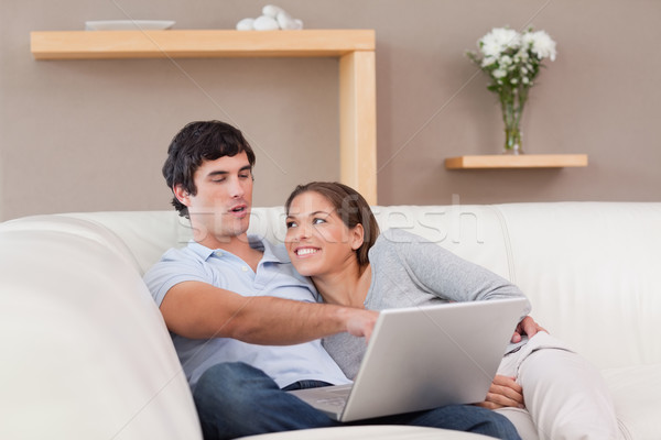 Stock photo: Young couple with their laptop on the sofa