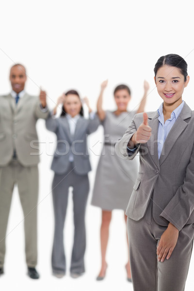 Close-up of a businesswoman approving with hand gesture with enthusiastic co-workers raising their a Stock photo © wavebreak_media