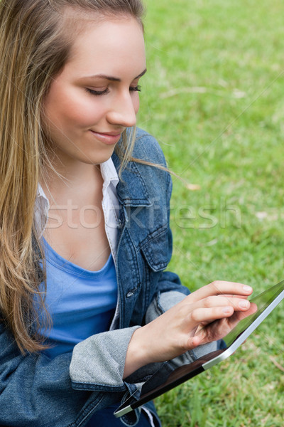 Young peaceful woman touching her tablet computer while sitting in the countryside Stock photo © wavebreak_media