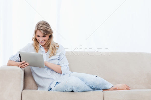 Jóvenes mujer sonriente sesión sofá tableta Foto stock © wavebreak_media