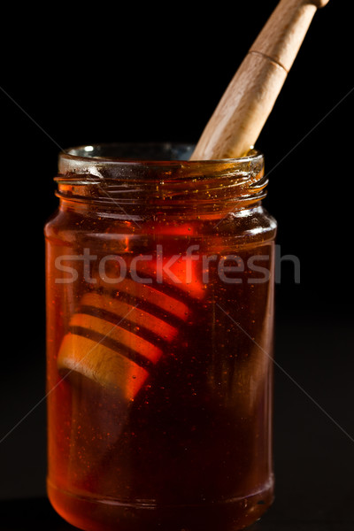 Honey dipper in a honey jar against a black background Stock photo © wavebreak_media