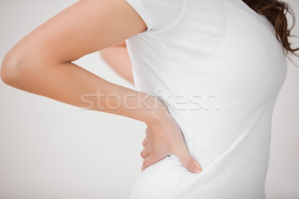 Woman putting her hands on her back indoors Stock photo © wavebreak_media