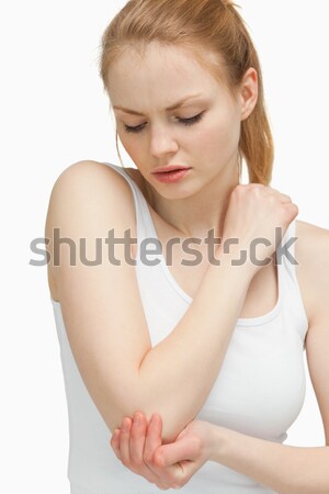 Blonde woman touching her elbow against white background Stock photo © wavebreak_media